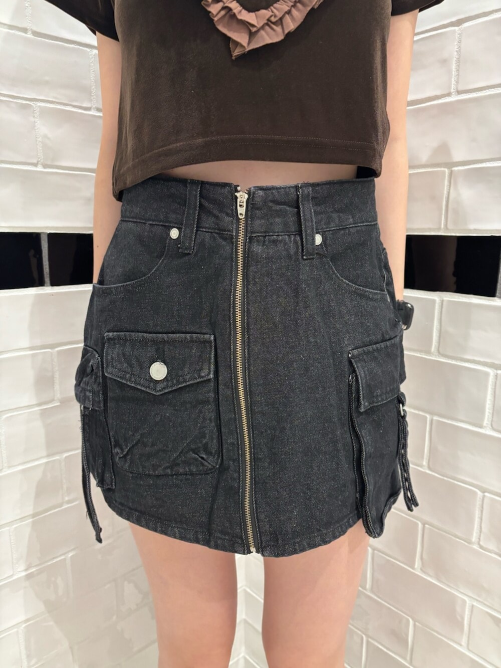 ホワイト系のショルダーバッグ、ブラウン系のTシャツ/カットソー、ブラック系のスニーカーを着用したレディースの夏コーディネートの5枚目の写真