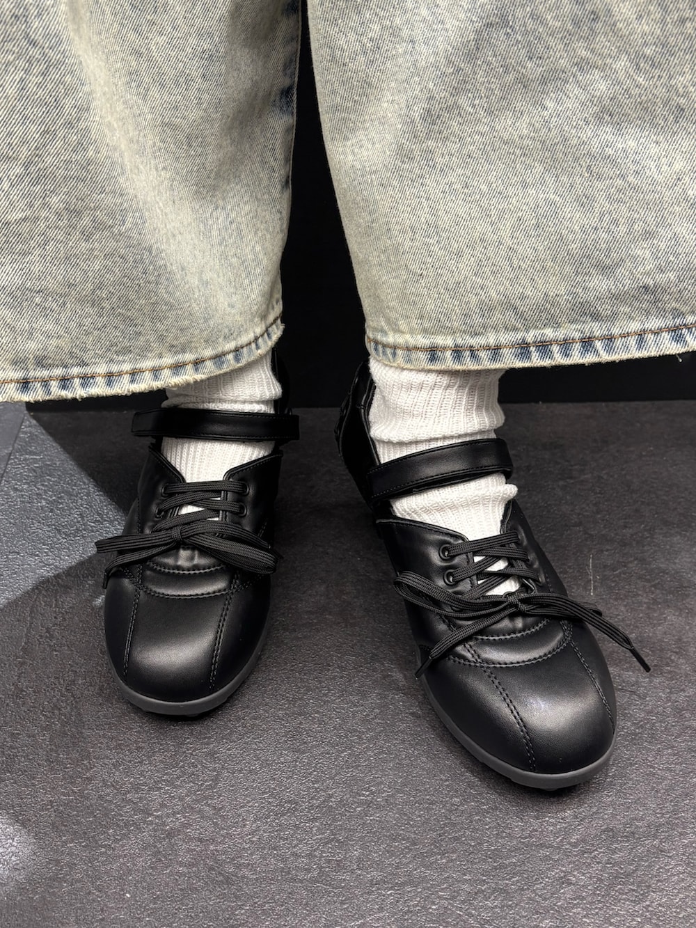 ブラック系のパーカー、ブルー系のデニムパンツ、ブラック系のスニーカーを着用したレディースの春コーディネートの6枚目の写真