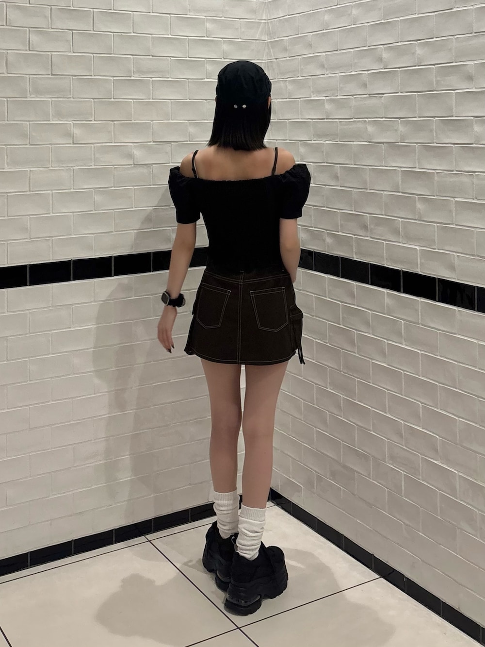 ブラック系のTシャツ/カットソー、ブラウン系のスカート、ブラック系のスニーカーを着用したレディースの夏コーディネートの3枚目の写真