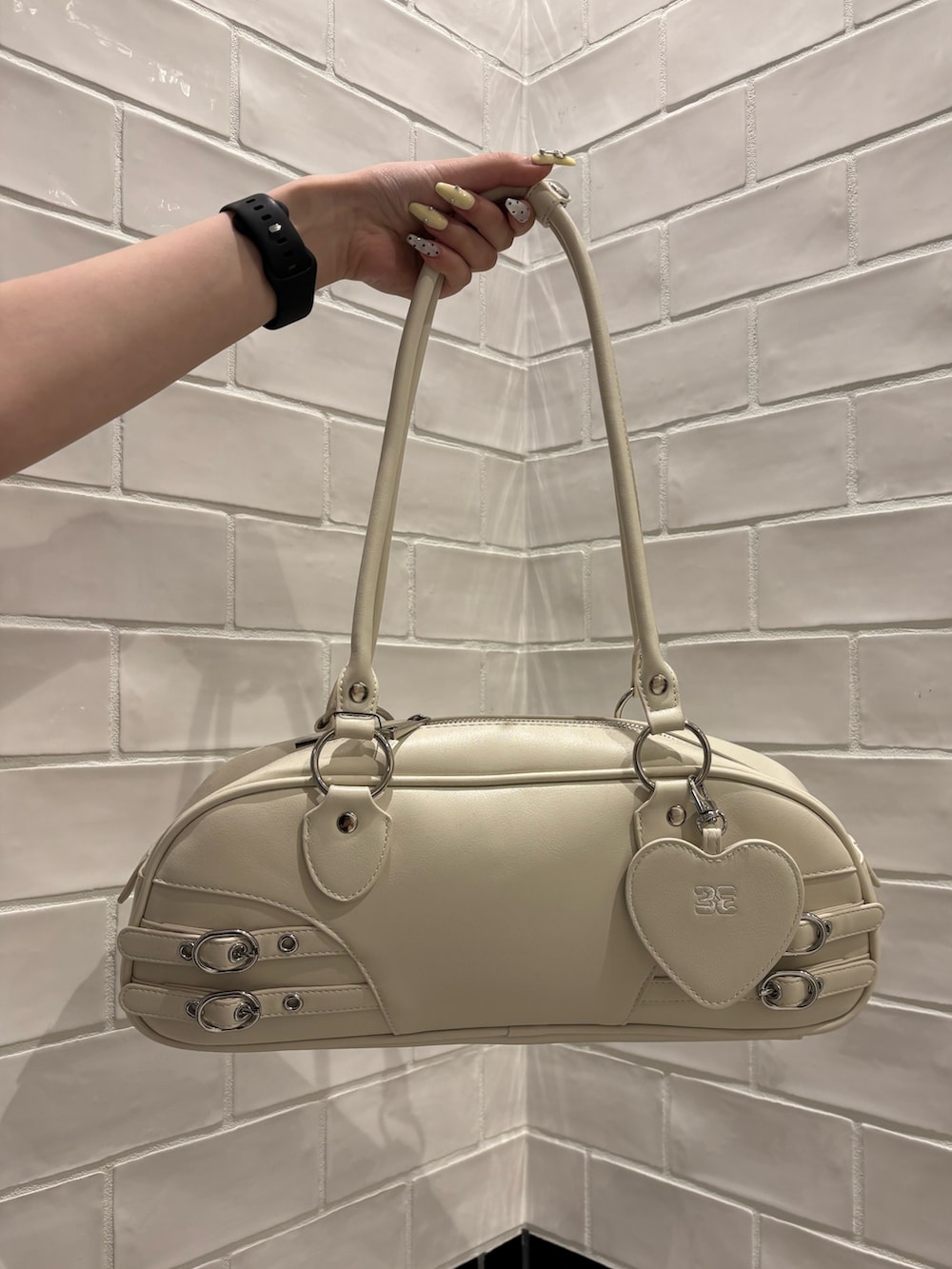 ブルー系のニット/セーター、ブラック系のデニムパンツ、ホワイト系のハンドバッグを着用したレディースの春コーディネートの7枚目の写真