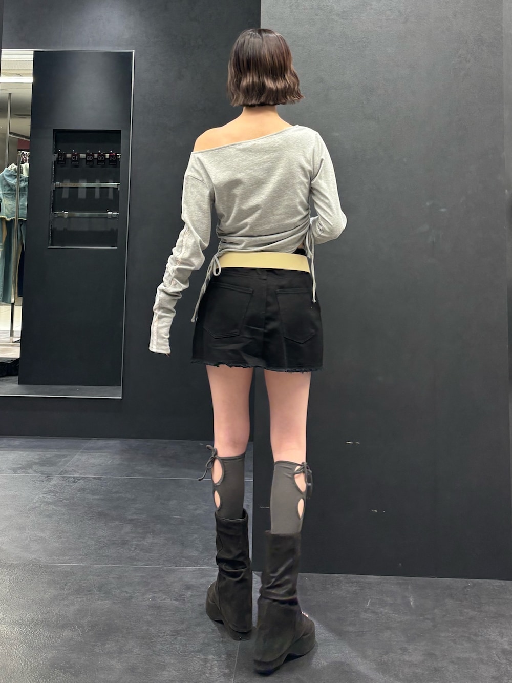 ブラック系のスカート、ブラック系のサンダル、グレー系のTシャツ/カットソーを着用したレディースの春コーディネートの3枚目の写真