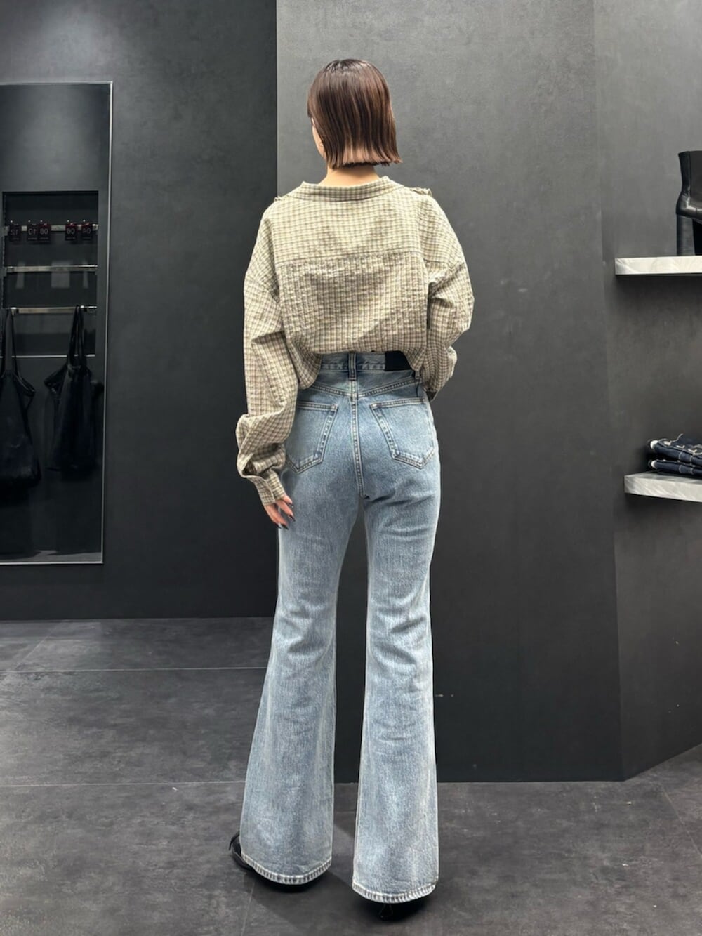 ブラック系のスニーカー、ブルー系のデニムパンツ、ベージュ系のシャツ/ブラウスを着用したレディースの春コーディネートの3枚目の写真