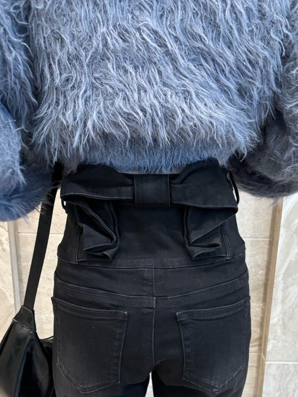 ブラック系のブーツ、グレー系のニット/セーター、ブラック系のデニムパンツを着用したレディースの冬コーディネートの7枚目の写真