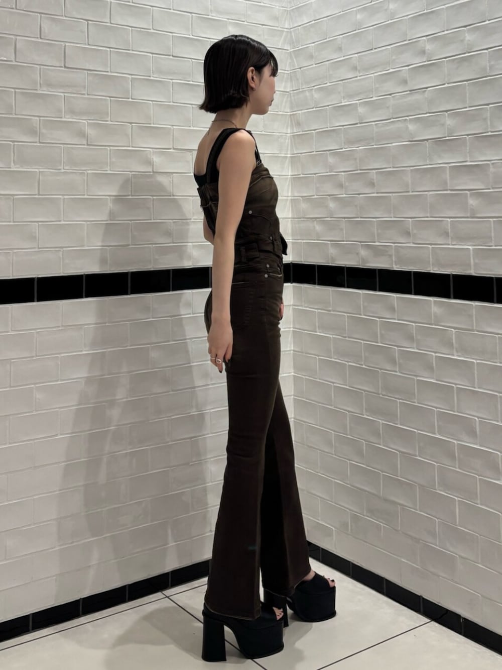 ブラック系のサンダル、ブラウン系のサロペット/オーバーオール、ブラック系のニット/セーターを着用したレディースの春コーディネートの2枚目の写真