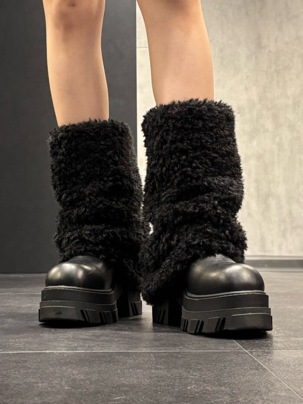 ブラウン系のニット/セーター、ブラック系のその他パンツ、ブラック系のブーツを着用したレディースの冬コーディネートの6枚目の写真