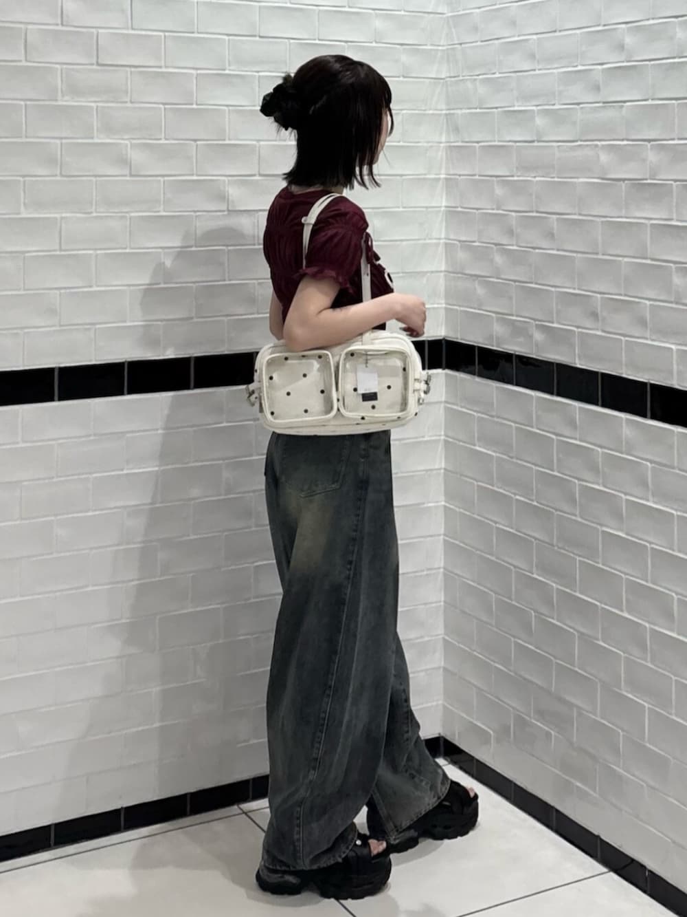 ホワイト系のショルダーバッグ、ブラック系のサンダル、ブルー系のデニムパンツを着用したレディースの夏コーディネートの2枚目の写真