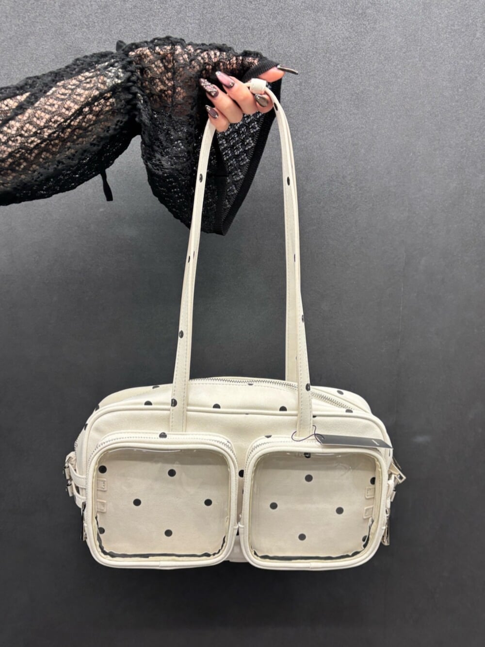 ブラック系のスニーカー、ブルー系のデニムパンツ、ブラック系のニット/セーターを着用したレディースの春コーディネートの7枚目の写真