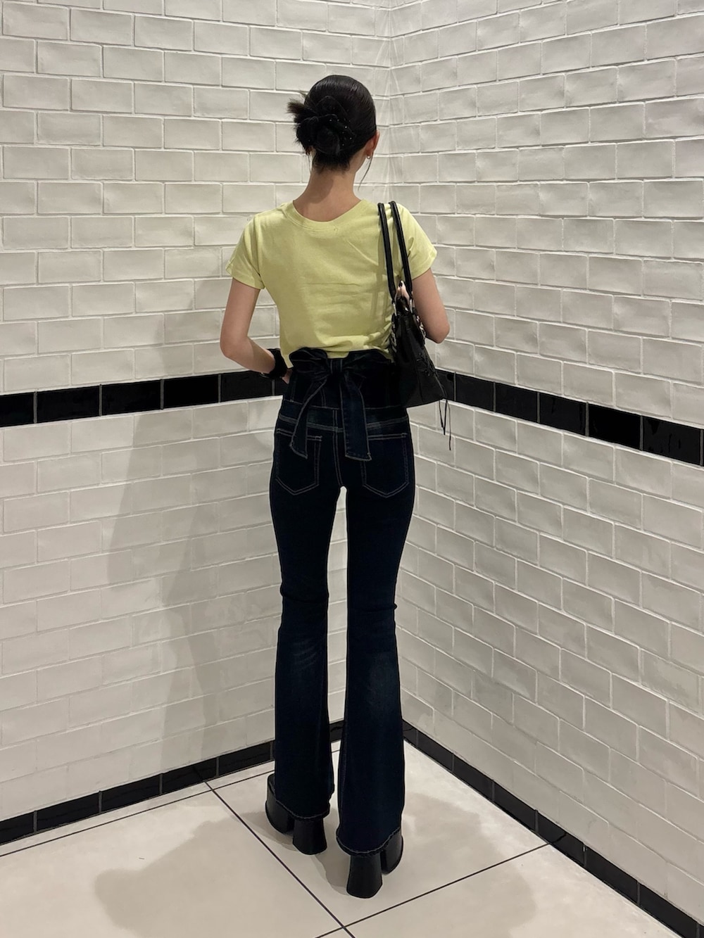 イエロー系のTシャツ/カットソー、ブルー系のデニムパンツ、ブラック系のサンダルを着用したレディースの夏コーディネートの3枚目の写真
