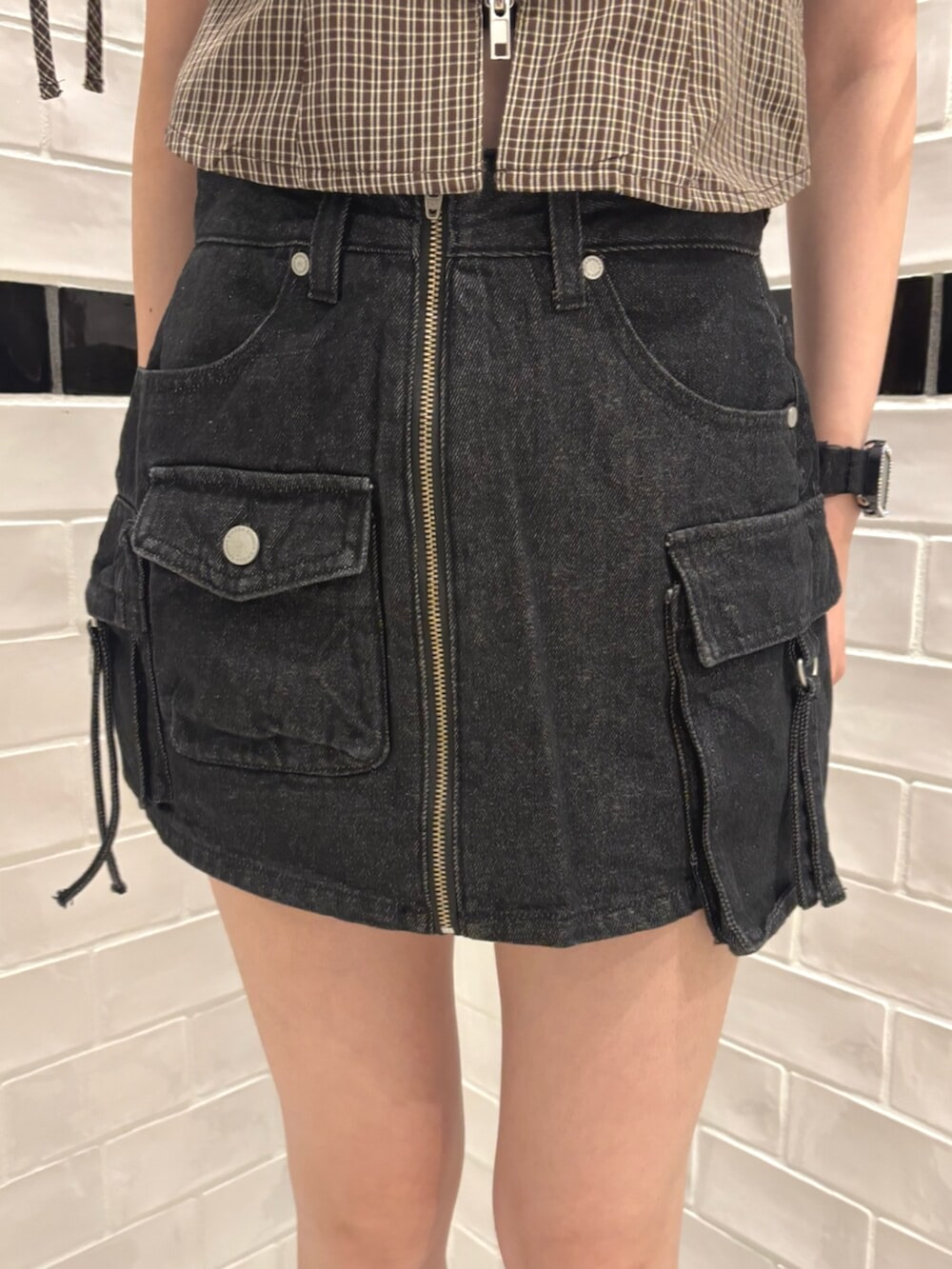 ブラック系のスカート、ブラック系のショルダーバッグ、ブラウン系のTシャツ/カットソーを着用したレディースの夏コーディネートの5枚目の写真