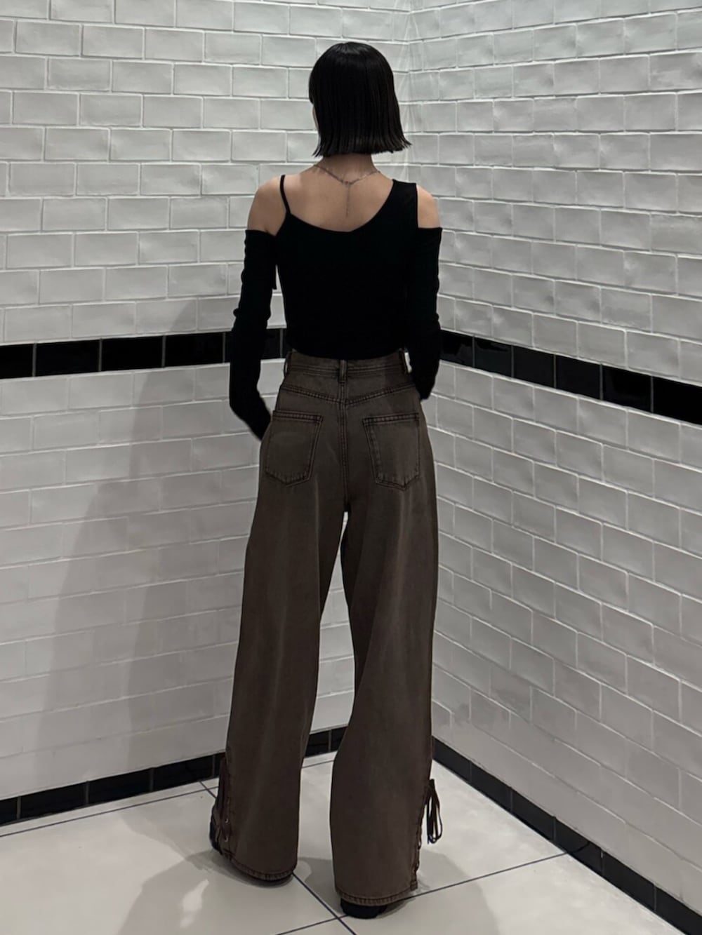 ブラック系のブーツ、ブラック系のTシャツ/カットソー、ブラウン系のデニムパンツを着用したレディースの春コーディネートの3枚目の写真