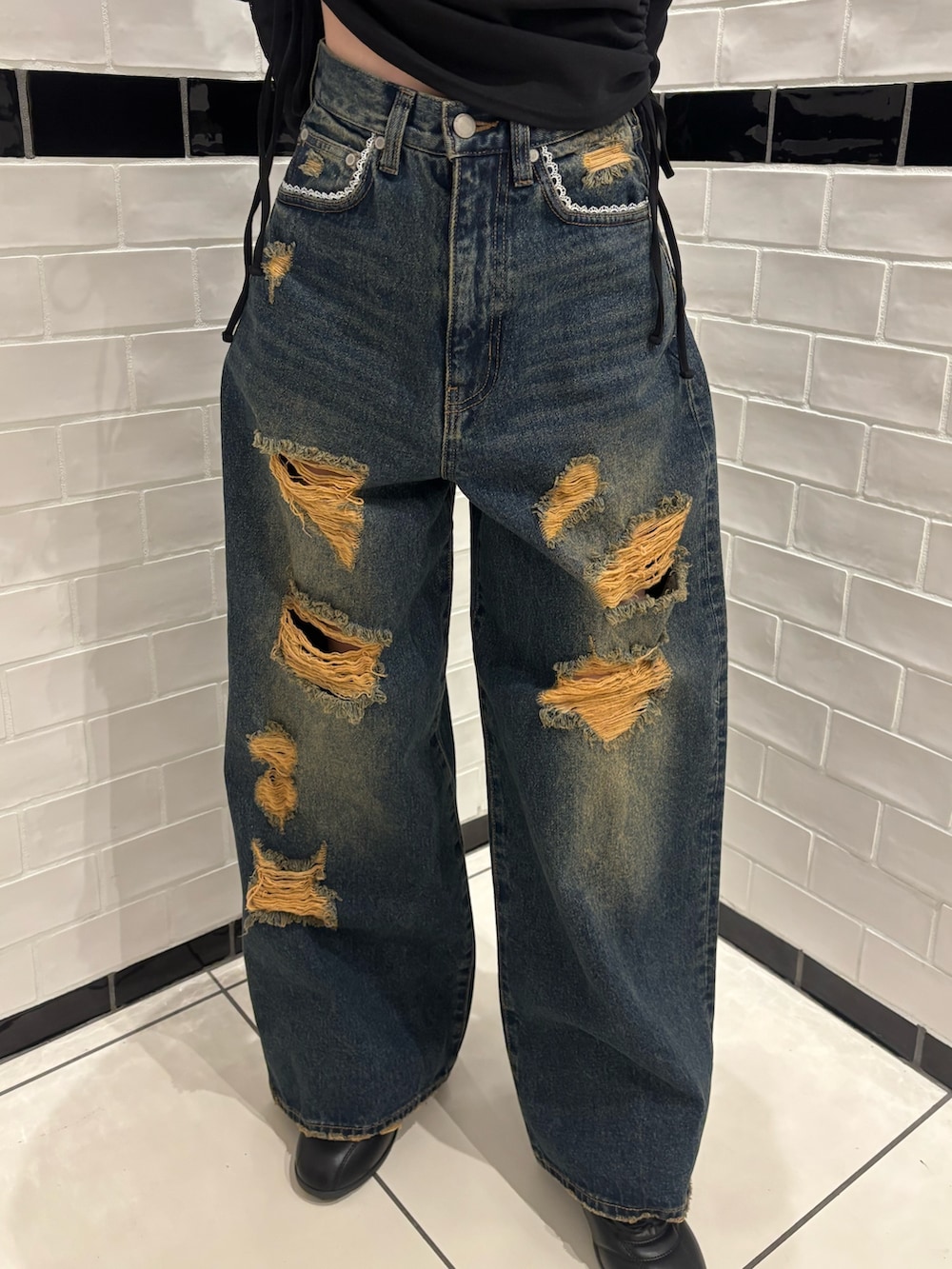 ブラック系のTシャツ/カットソー、ブルー系のデニムパンツ、ブラック系のスニーカーを着用したレディースの春コーディネートの5枚目の写真