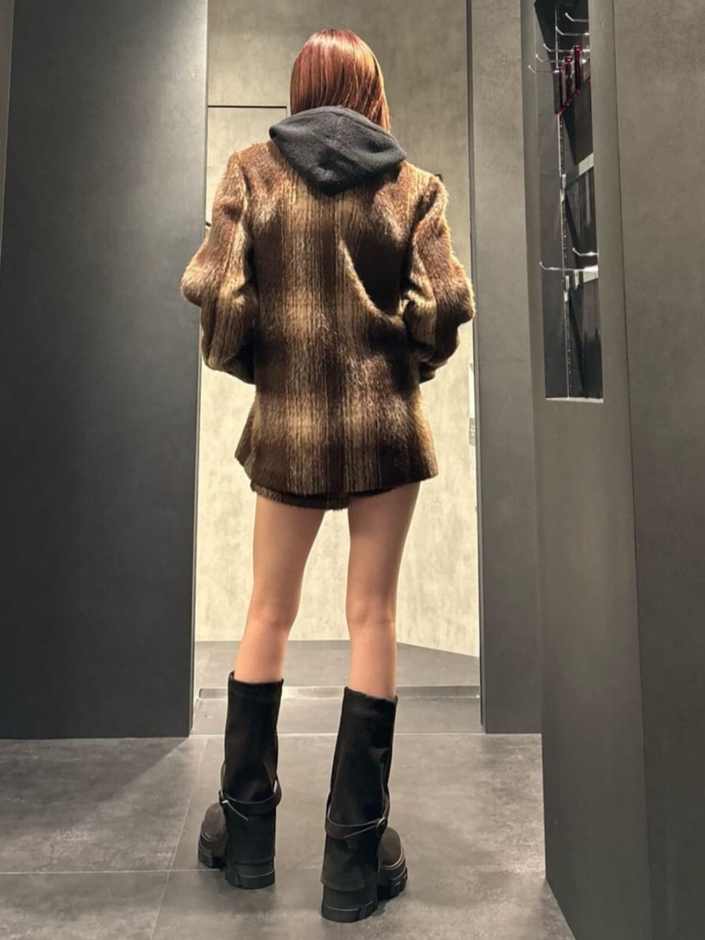 ブラック系のブーツ、ブラウン系のその他アウター、ブラック系のパーカーを着用したレディースの冬コーディネートの4枚目の写真