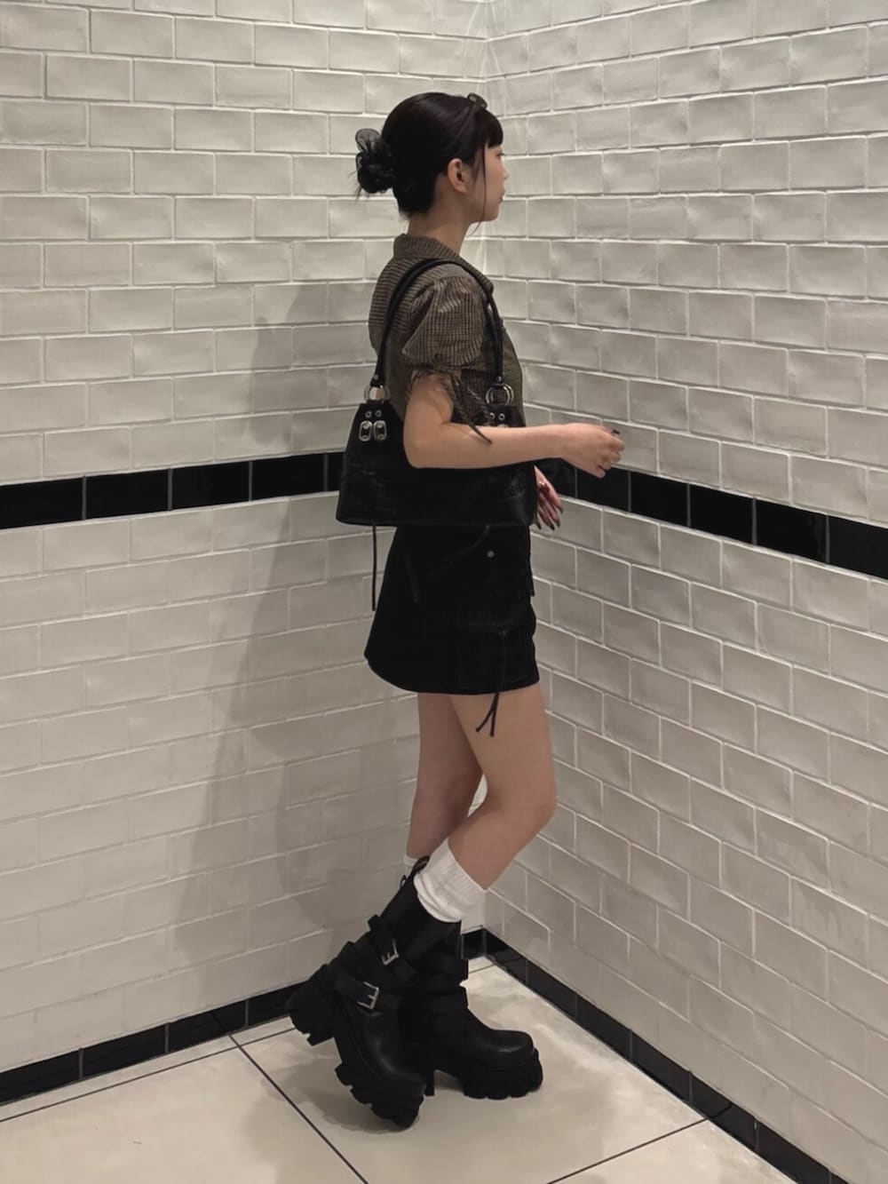 ブラック系のスカート、ブラック系のショルダーバッグ、ブラウン系のTシャツ/カットソーを着用したレディースの夏コーディネートの2枚目の写真