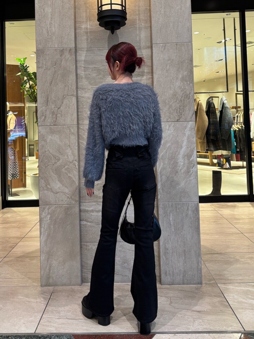 ブラック系のブーツ、グレー系のニット/セーター、ブラック系のデニムパンツを着用したレディースの冬コーディネートの4枚目の写真