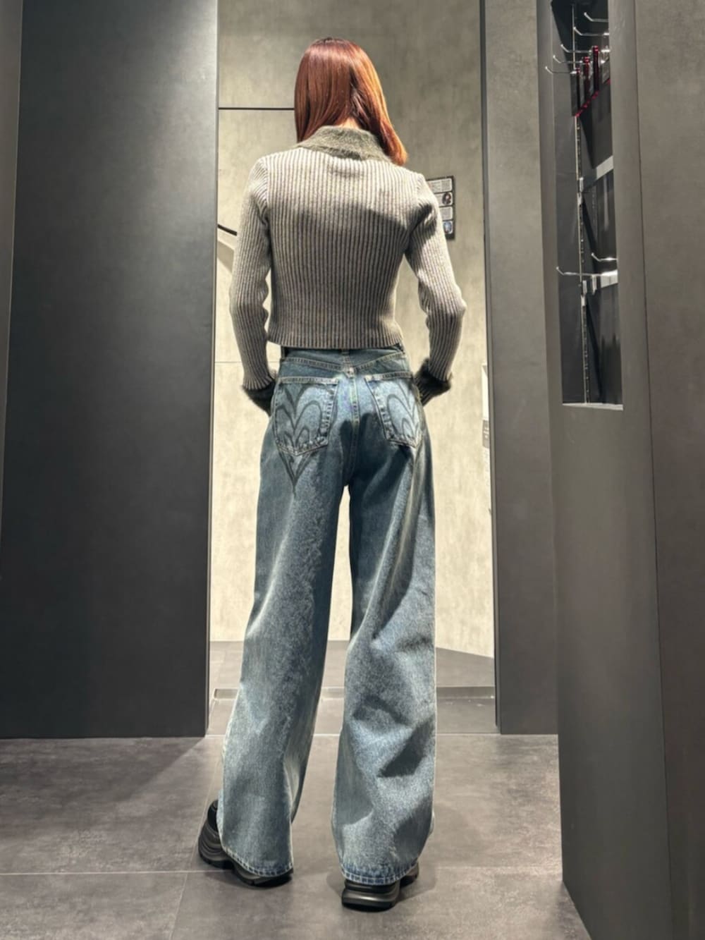 グレー系のニット/セーター、ブルー系のデニムパンツ、ブラック系のローファーを着用したレディースの冬コーディネートの3枚目の写真