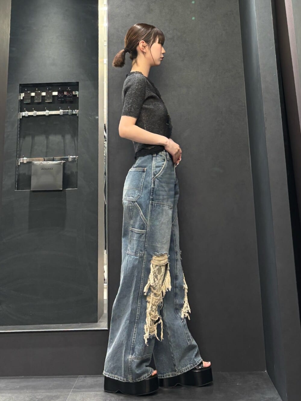 ブラック系のサンダル、ブラック系のニット/セーター、ブルー系のデニムパンツを着用したレディースの春コーディネートの2枚目の写真