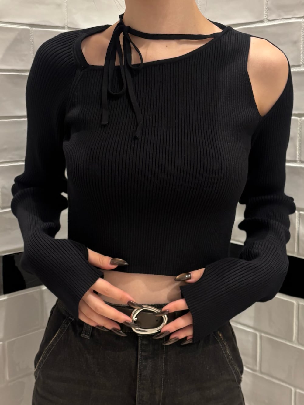 ブラック系のニット/セーター、ブラック系のデニムパンツ、ブラウン系のショルダーバッグを着用したレディースの秋コーディネートの4枚目の写真