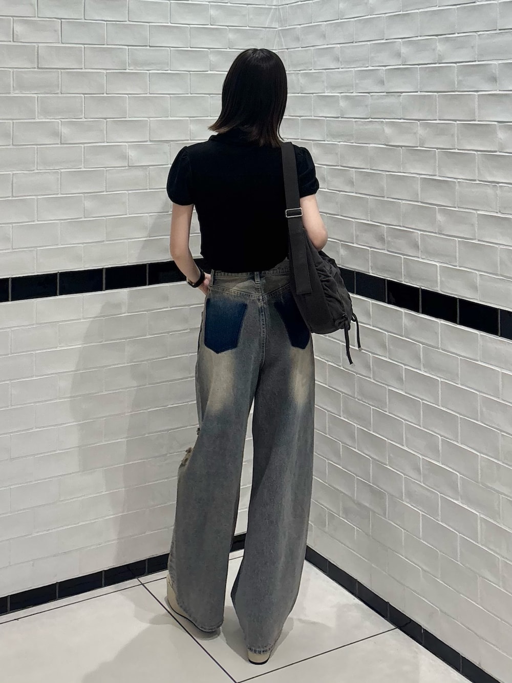 ブラック系のシャツ/ブラウス、ブルー系のデニムパンツ、ホワイト系のサンダルを着用したレディースの夏コーディネートの3枚目の写真