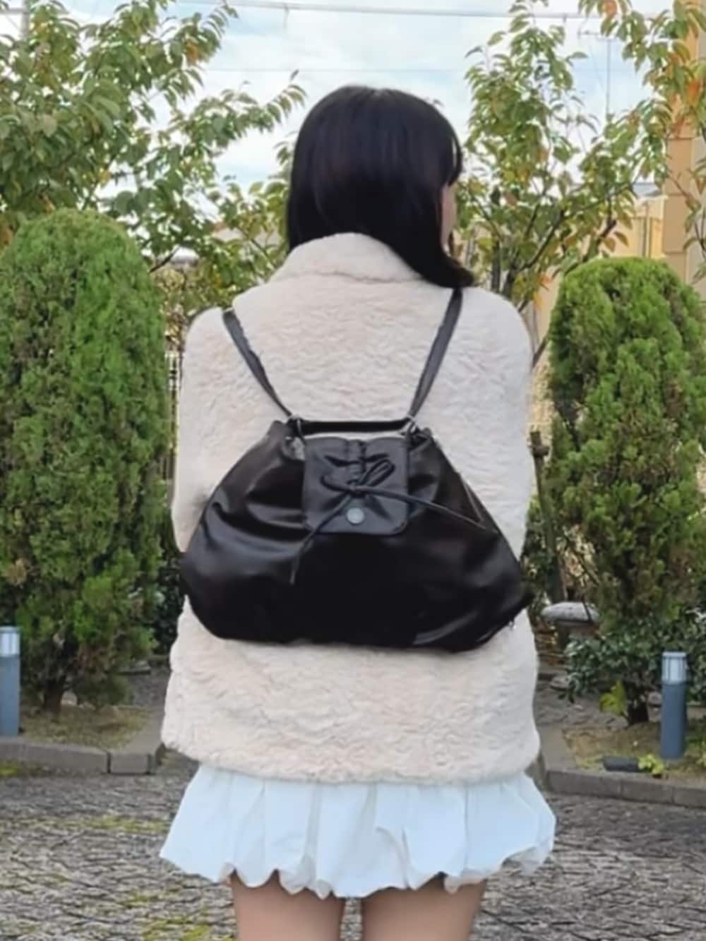 ブラウン系のショルダーバッグを着用したレディースの冬コーディネートの3枚目の写真