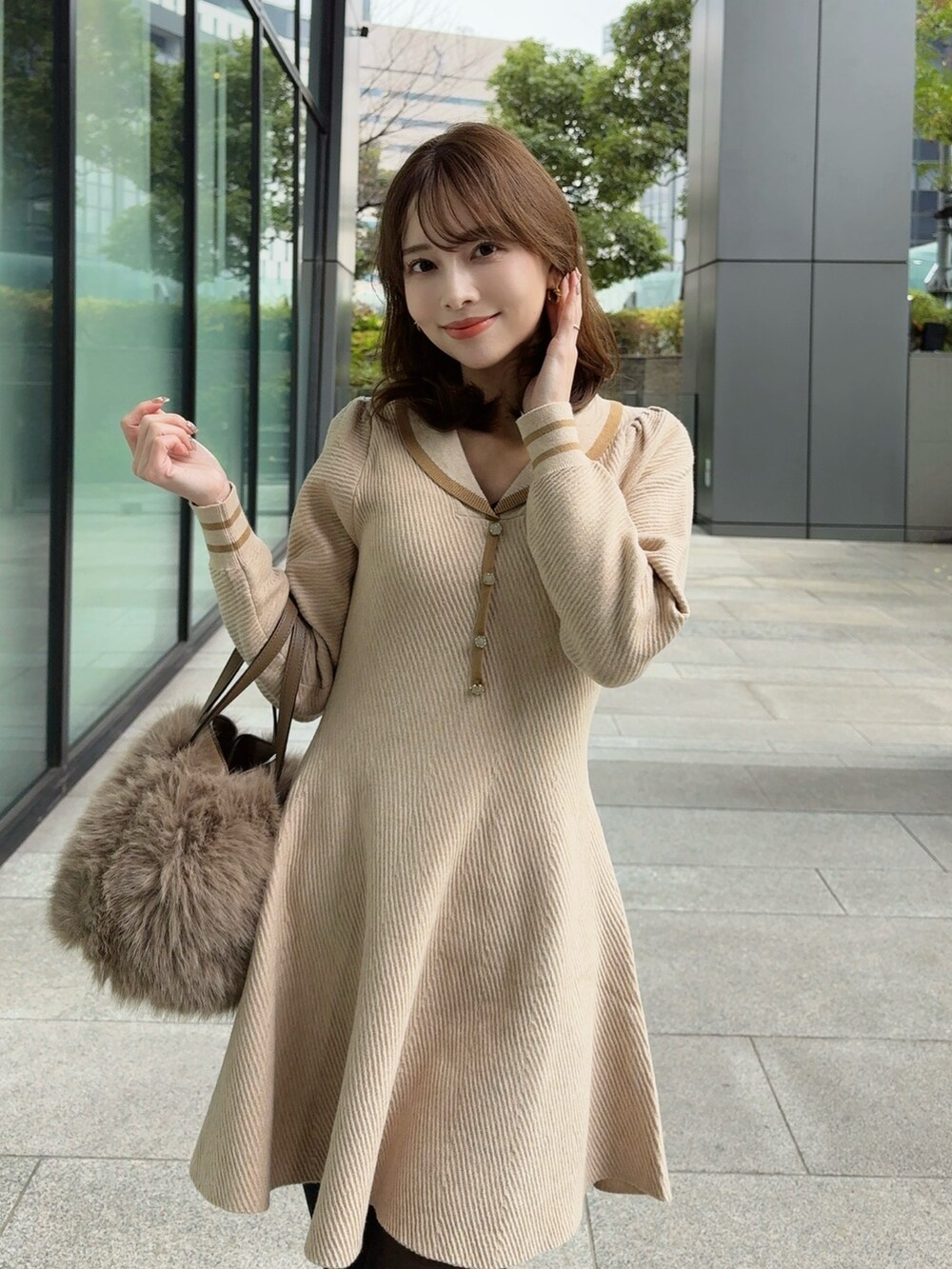 ベージュ系のワンピースを着用したレディースの冬コーディネートの2枚目の写真