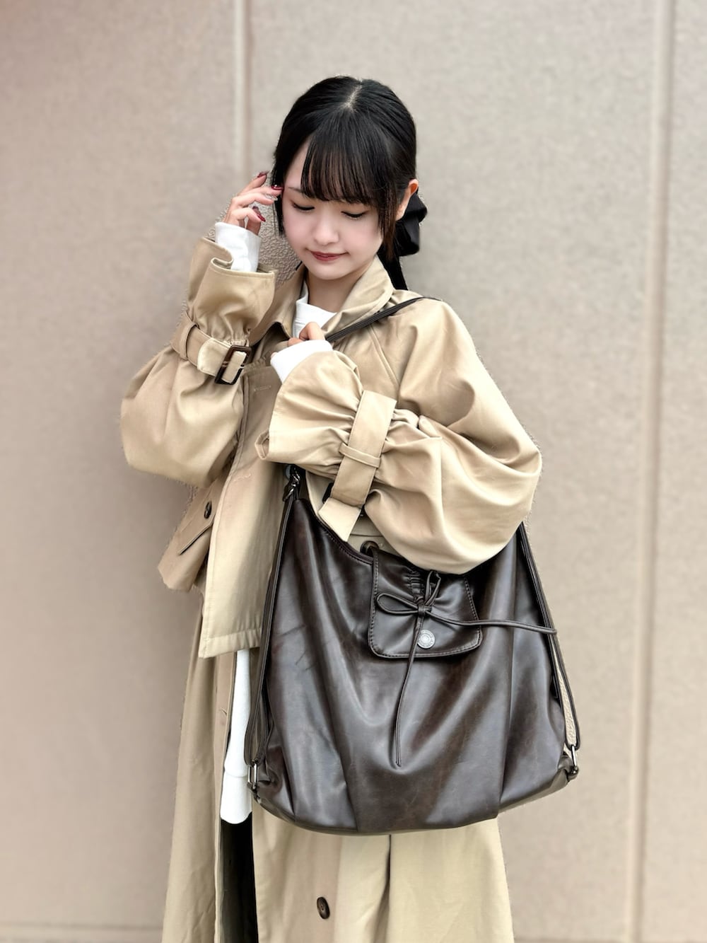 ブラウン系のショルダーバッグを着用したレディースの秋コーディネートの2枚目の写真