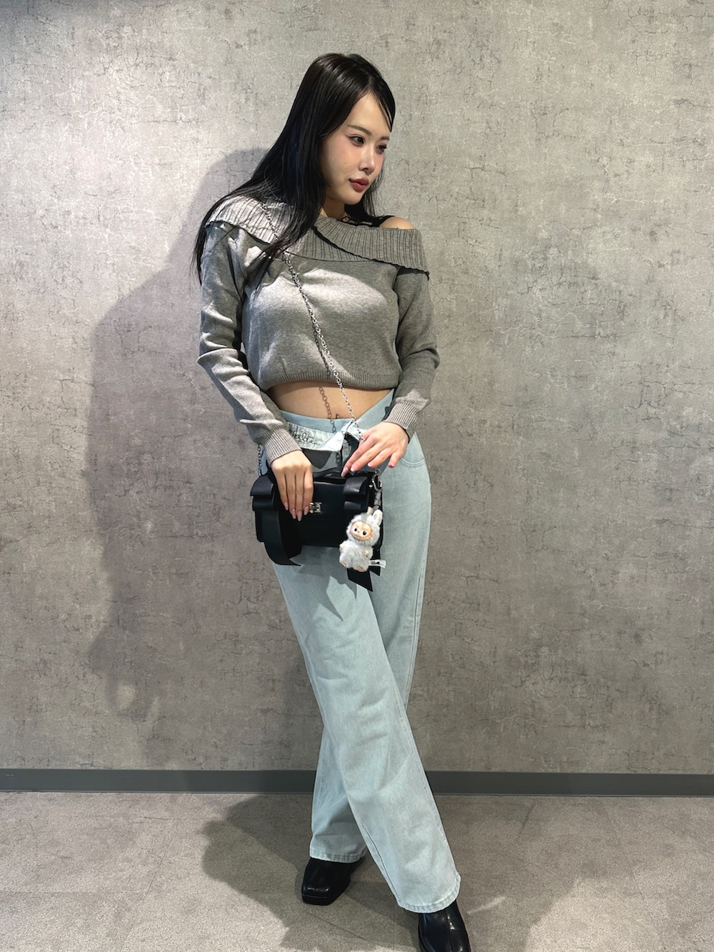 グレー系のニット/セーター、ブルー系のデニムパンツを着用したレディースの冬コーディネートの2枚目の写真