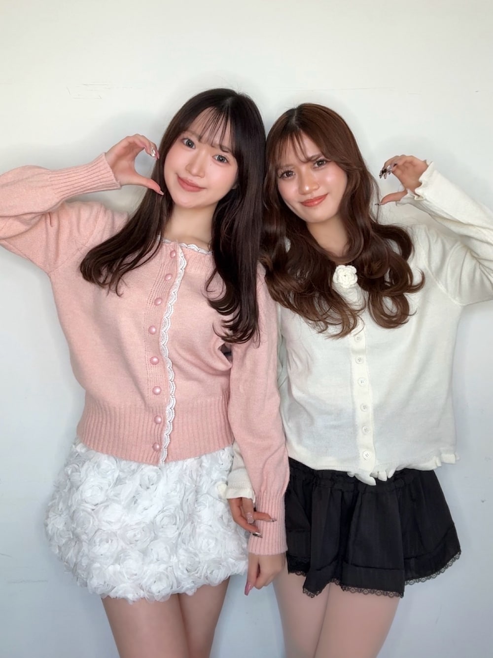 ブラック系のスカート、ホワイト系のニット/セーター、ピンク系のカーディガン/ボレロを着用したレディースの冬コーディネートの2枚目の写真