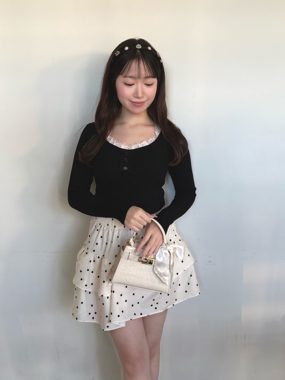 ブラック系のニット/セーター、ホワイト系のスカートを着用したレディースの冬コーディネートの3枚目の写真