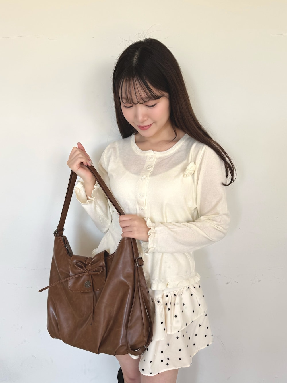 ホワイト系のスカート、イエロー系のショルダーバッグを着用したレディースの冬コーディネートの2枚目の写真