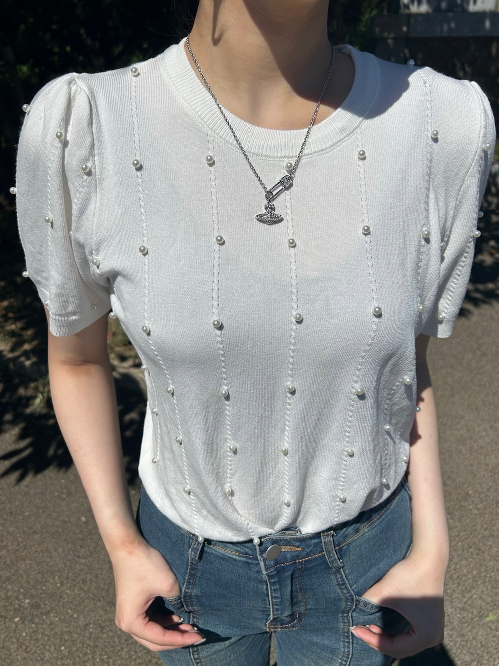 ホワイト系のニット/セーターを着用したレディースの夏コーディネートの3枚目の写真