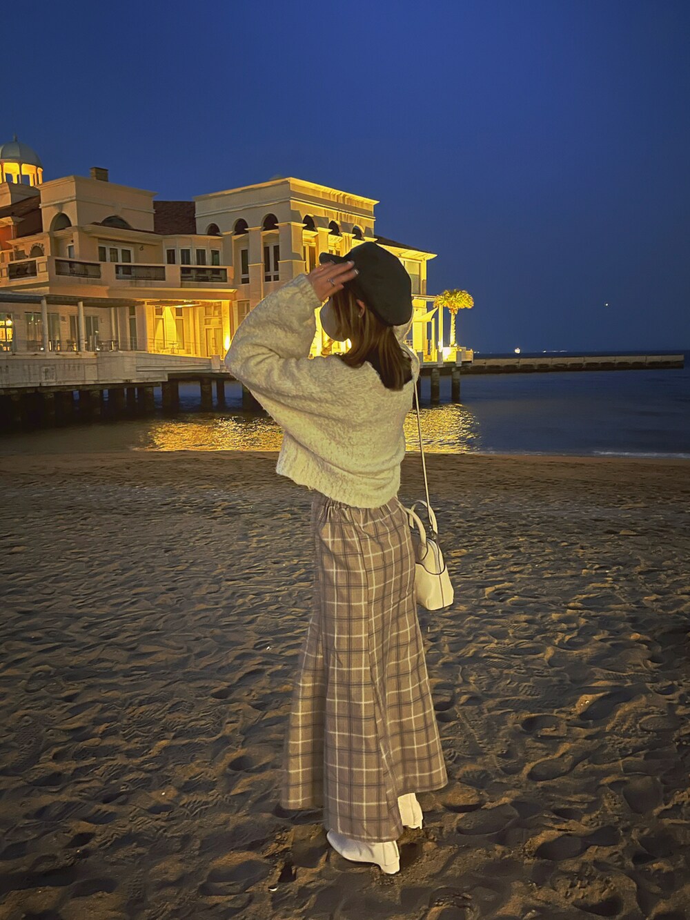 ブラウン系のスカート、ホワイト系のブーツ、ホワイト系のカーディガン/ボレロを着用したレディースの春コーディネートの2枚目の写真