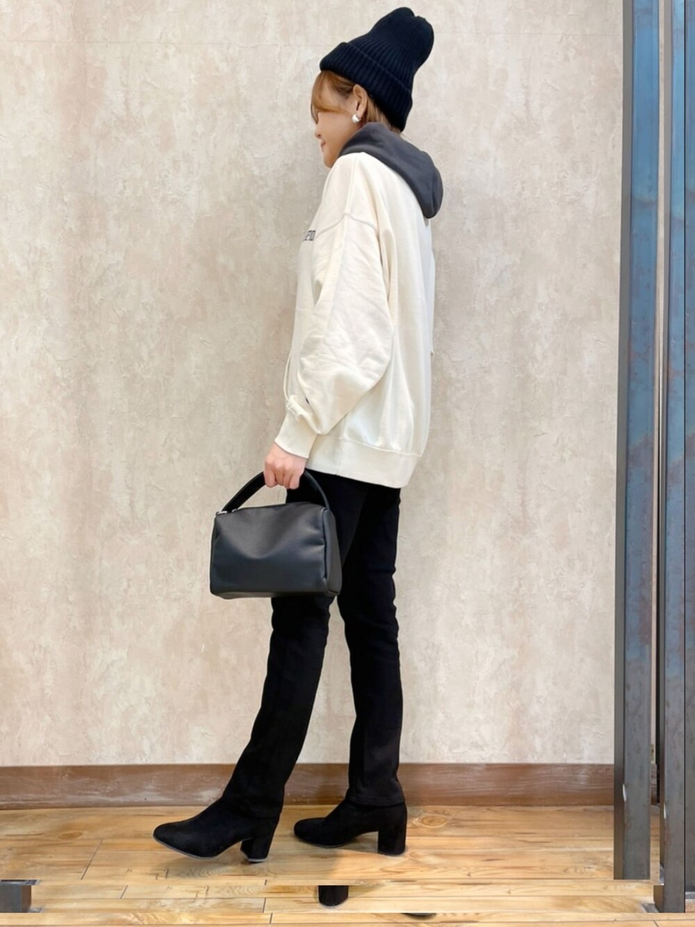 グリーン系のダウンジャケット/コート、ホワイト系のパーカー、ブラック系のハンドバッグを着用したレディースの冬コーディネートの5枚目の写真