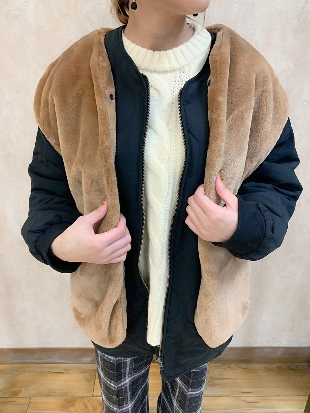 ホワイト系のニット/セーター、ブラック系のダウンジャケット/コート、グレー系のスラックスを着用したレディースの秋コーディネートの5枚目の写真