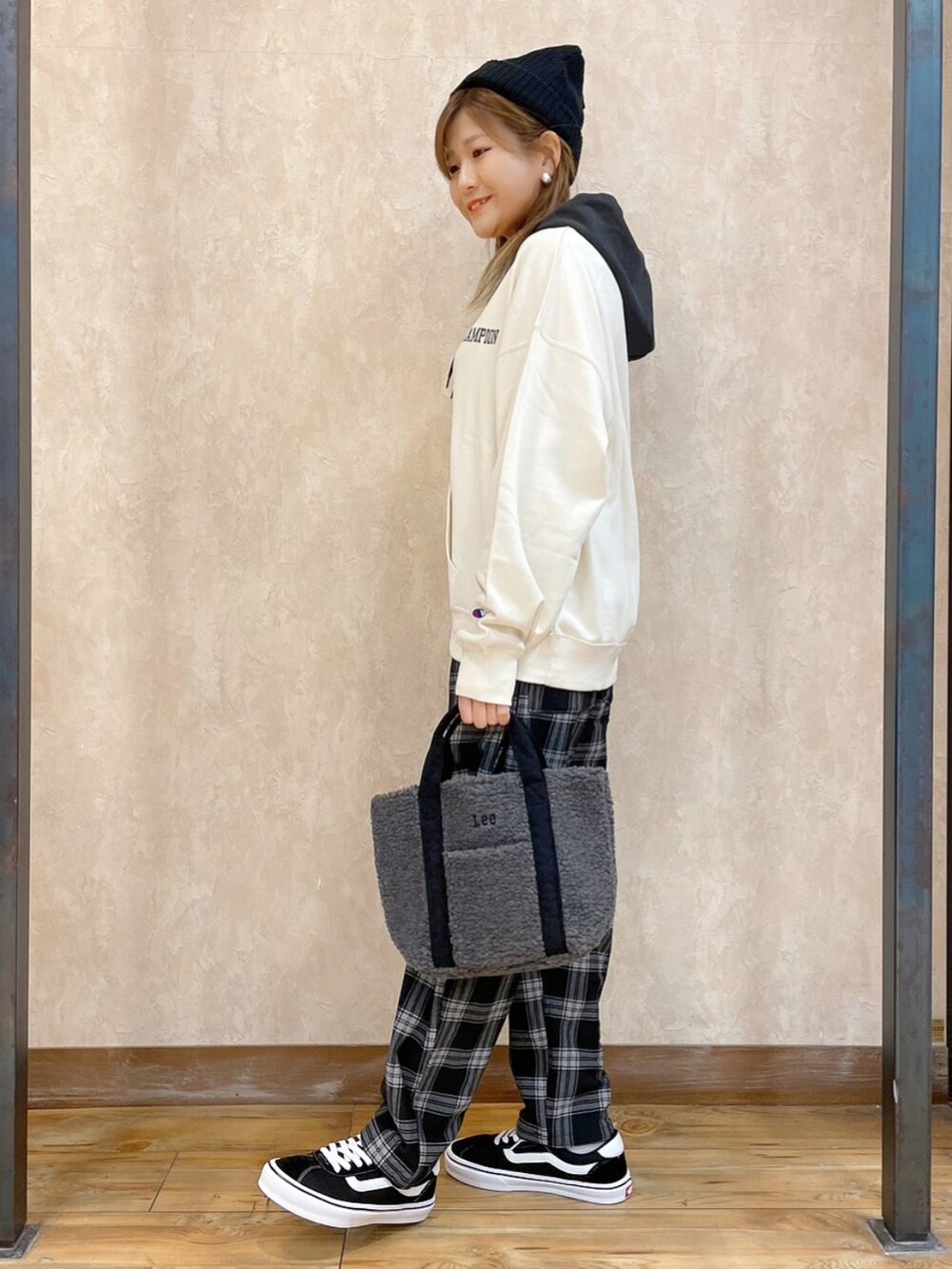 ホワイト系のパーカー、グレー系のトートバッグ、ブラック系のその他パンツを着用したレディースの冬コーディネートの4枚目の写真