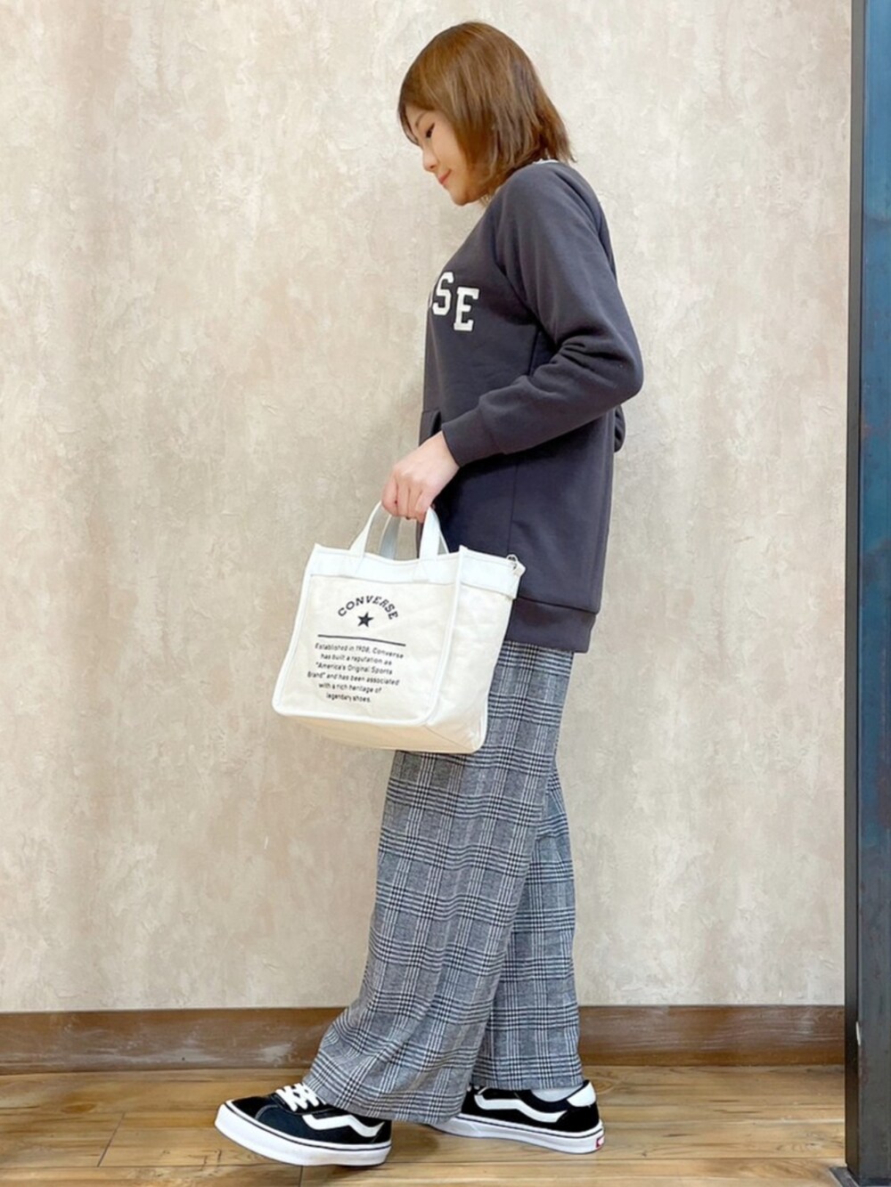 オレンジ系のブルゾン、ブラック系のスウェット、ホワイト系のショルダーバッグを着用したレディースの冬コーディネートの5枚目の写真