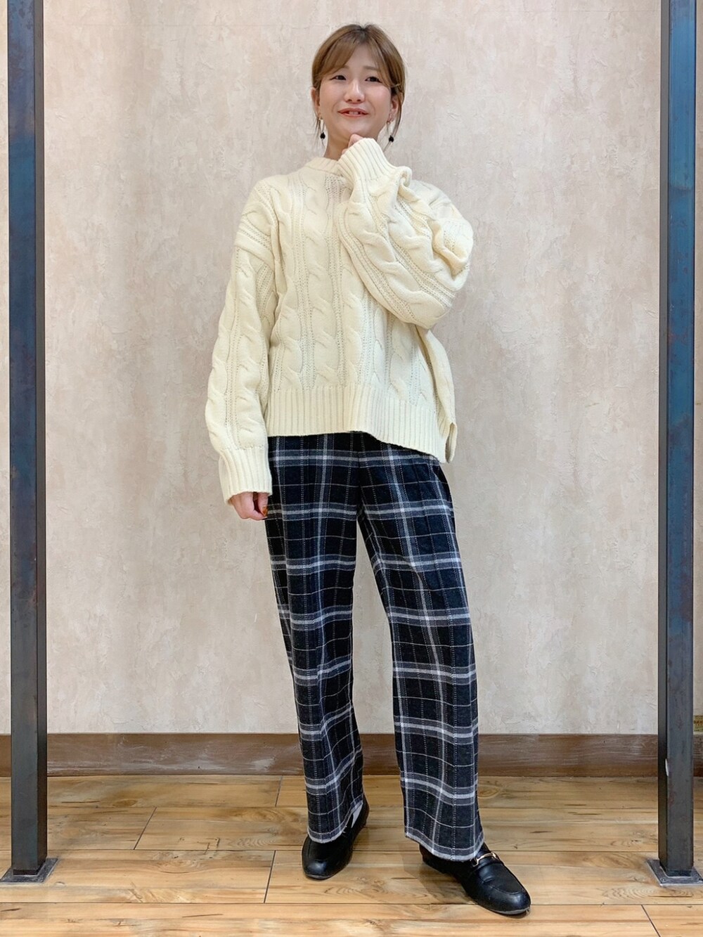 ホワイト系のニット/セーター、ブラック系のダウンジャケット/コート、グレー系のスラックスを着用したレディースの秋コーディネートの3枚目の写真