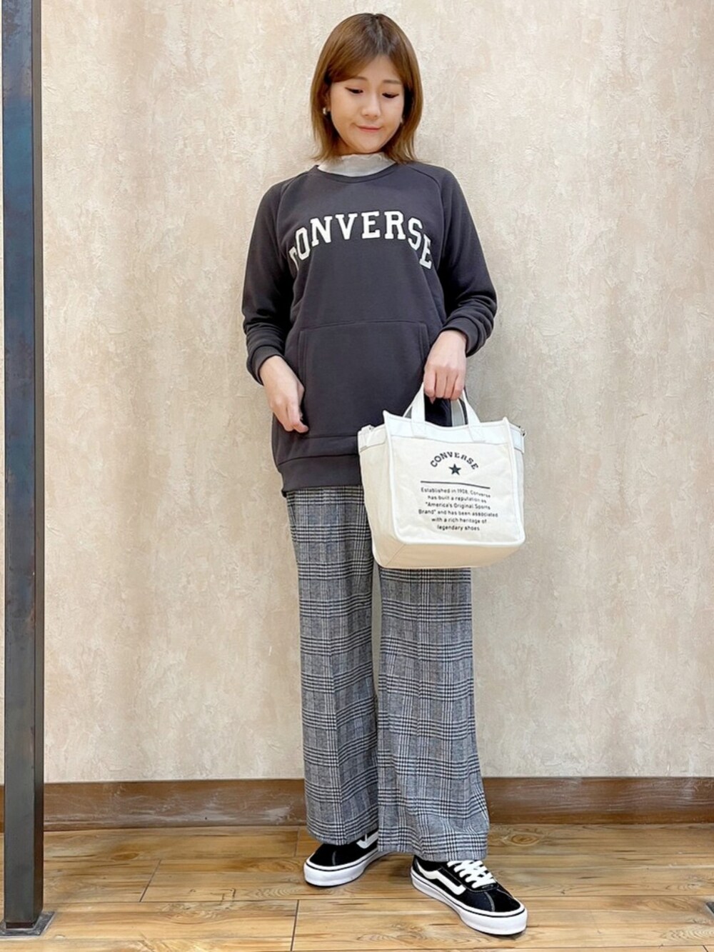 オレンジ系のブルゾン、ブラック系のスウェット、ホワイト系のショルダーバッグを着用したレディースの冬コーディネートの4枚目の写真