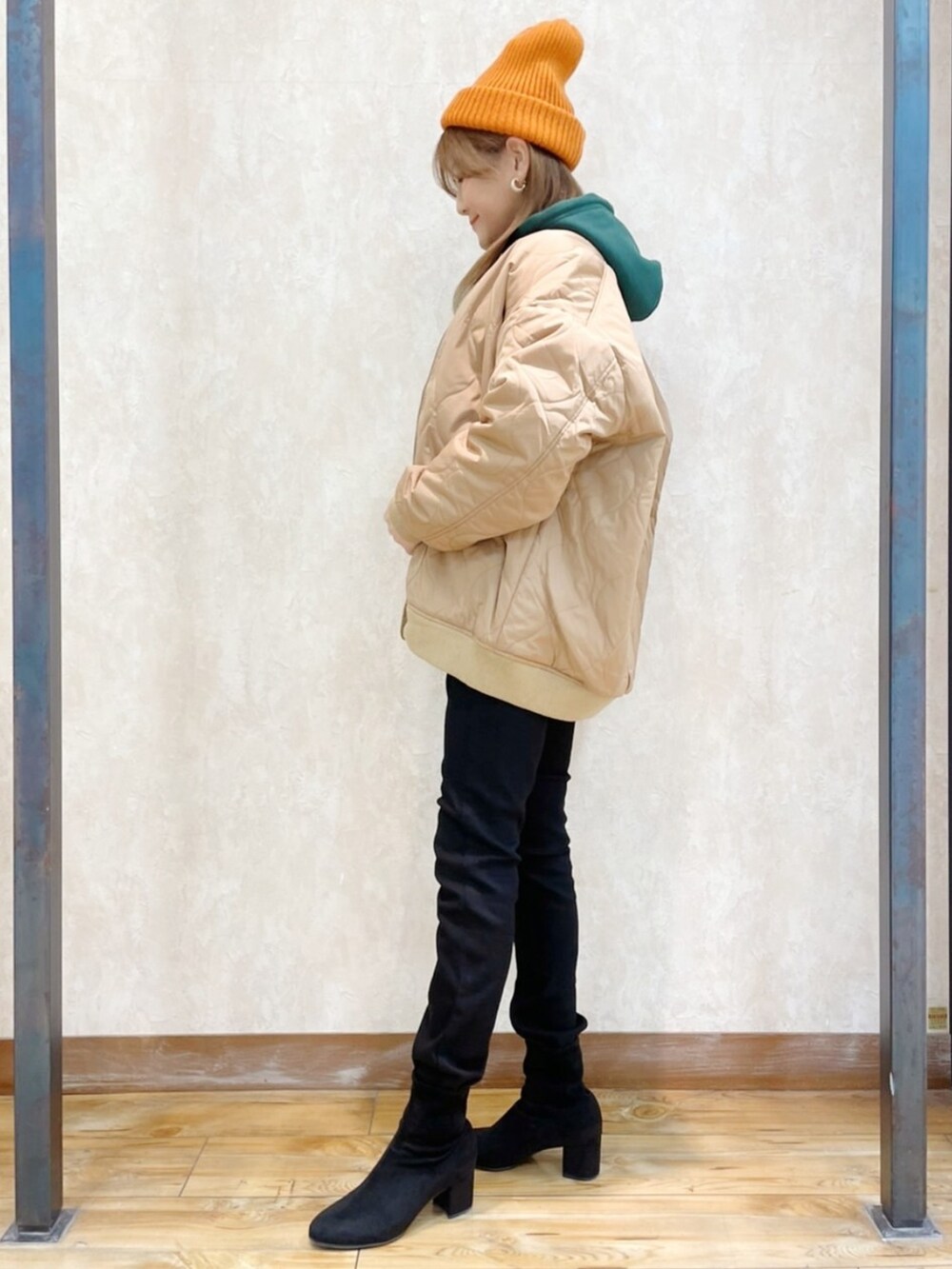 ブラウン系のブルゾン、グリーン系のパーカー、ブラック系のデニムパンツを着用したレディースの冬コーディネートの4枚目の写真