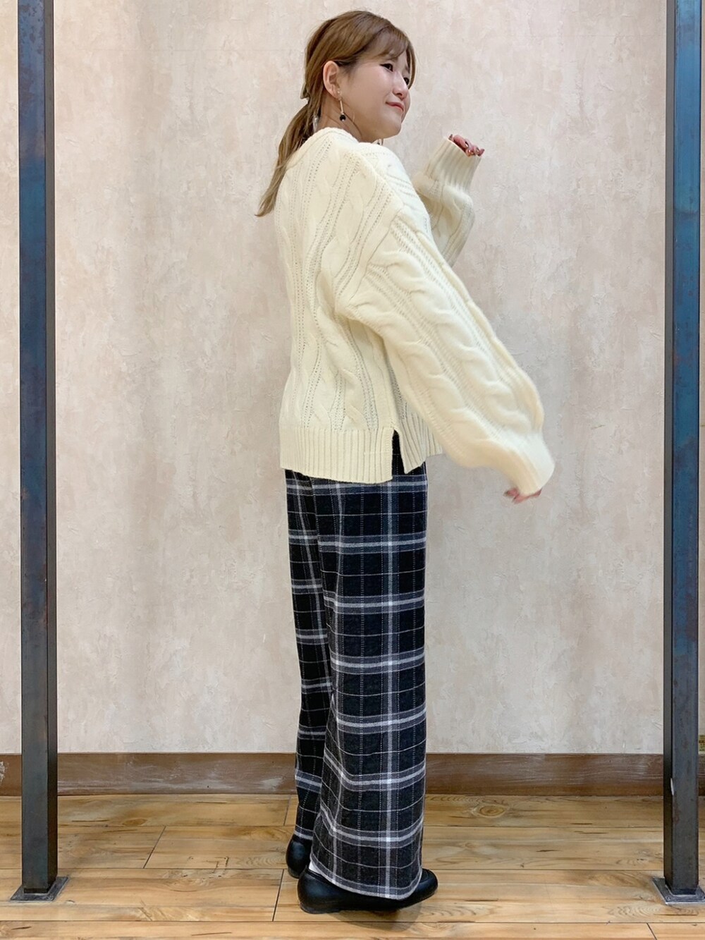 ホワイト系のニット/セーター、ブラック系のダウンジャケット/コート、グレー系のスラックスを着用したレディースの秋コーディネートの4枚目の写真