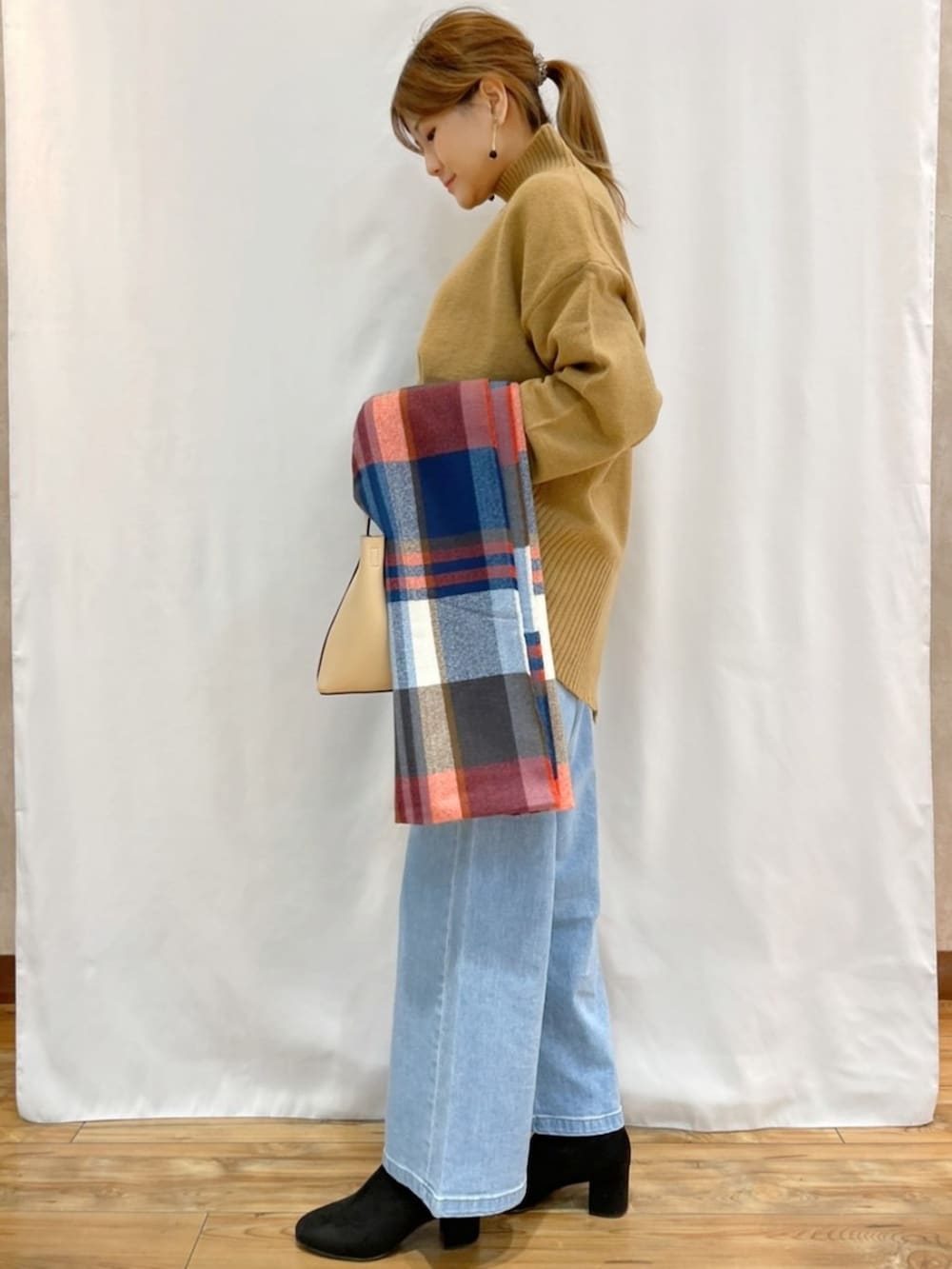 イエロー系のニット/セーター、ブルー系のデニムパンツ、その他のマフラーを着用したレディースの秋コーディネートの3枚目の写真