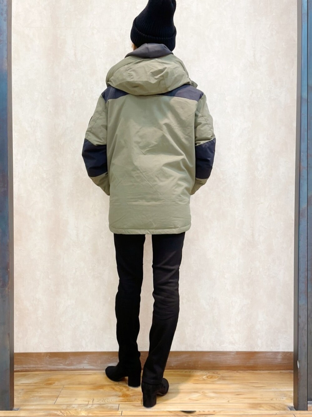 グリーン系のダウンジャケット/コート、ホワイト系のパーカー、ブラック系のハンドバッグを着用したレディースの冬コーディネートの3枚目の写真