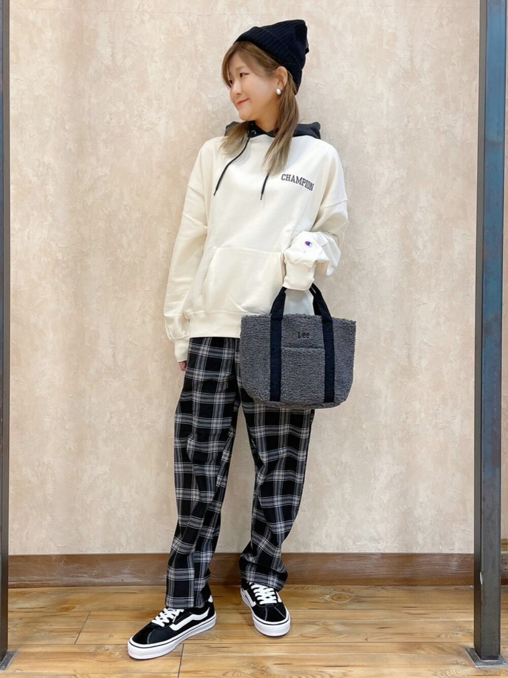 ホワイト系のパーカー、グレー系のトートバッグ、ブラック系のその他パンツを着用したレディースの冬コーディネートの3枚目の写真