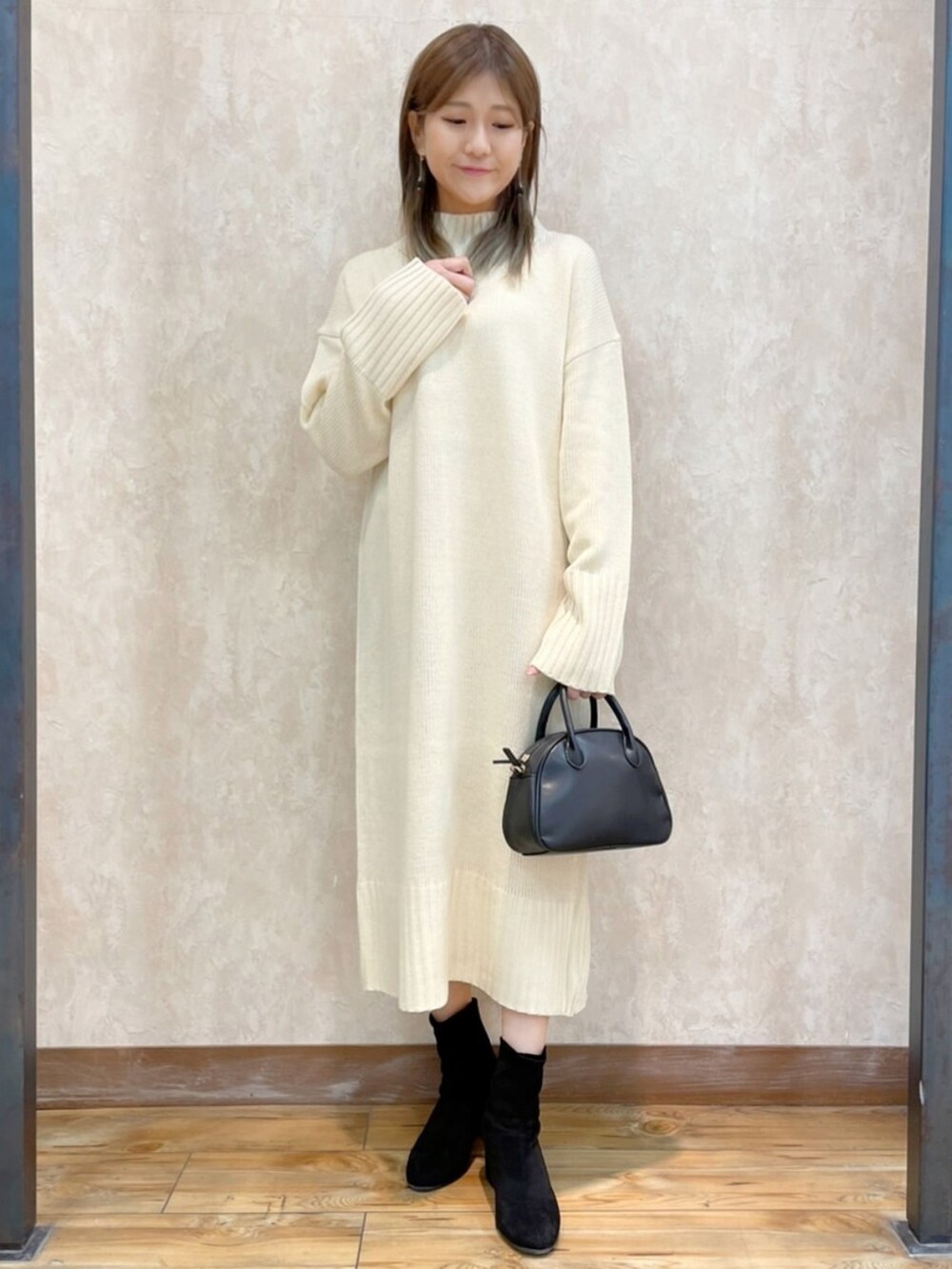 ホワイト系のワンピース、グレー系のダウンジャケット/コート、ブラック系のバッグを着用したレディースの冬コーディネートの4枚目の写真