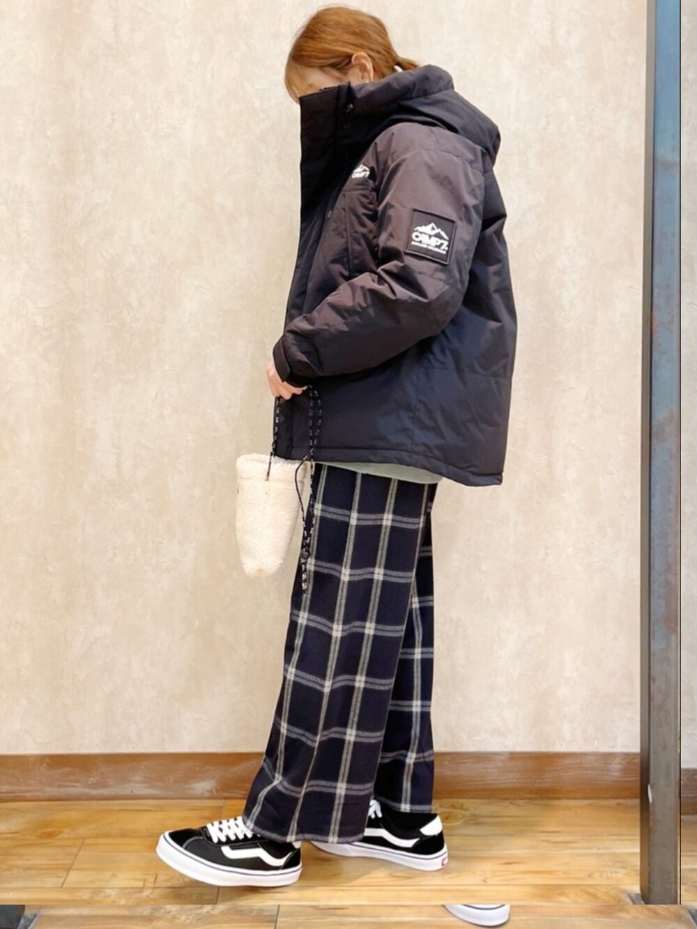 ブラック系のダウンジャケット/コート、グリーン系のスウェット、ホワイト系のスラックスを着用したレディースの冬コーディネートの3枚目の写真