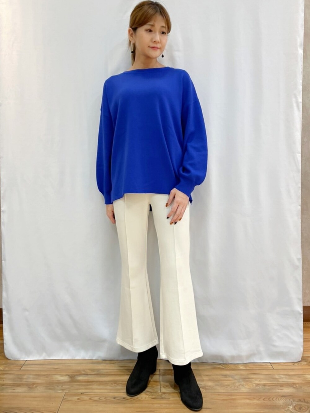 ブルー系のニット/セーター、グレー系のダウンジャケット/コート、ブラック系のショルダーバッグを着用したレディースの秋コーディネートの5枚目の写真