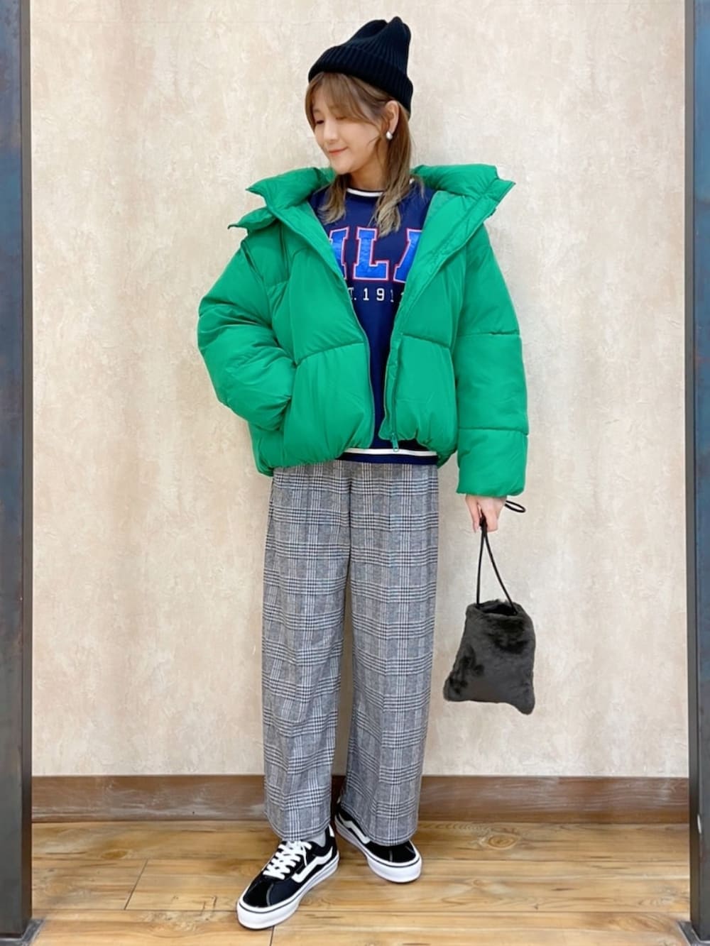 グリーン系のブルゾン、ブルー系のスウェット、ブラック系のスラックスを着用したレディースの冬コーディネートの2枚目の写真