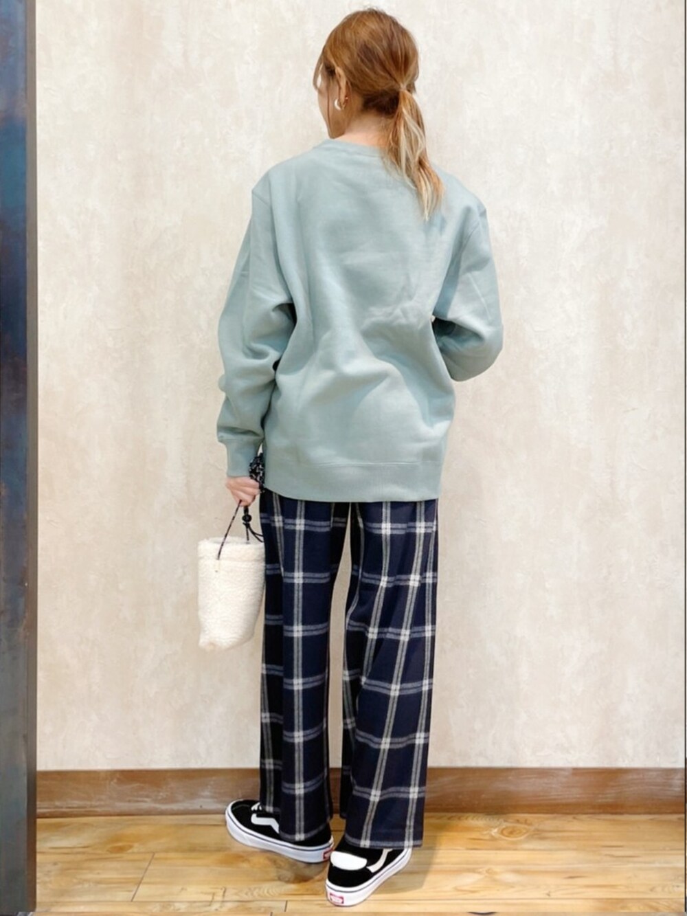 ブラック系のダウンジャケット/コート、グリーン系のスウェット、ホワイト系のスラックスを着用したレディースの冬コーディネートの5枚目の写真