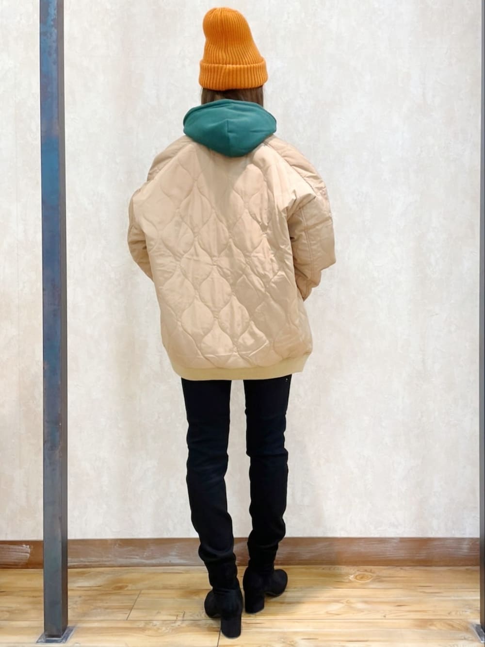 ブラウン系のブルゾン、グリーン系のパーカー、ブラック系のデニムパンツを着用したレディースの冬コーディネートの5枚目の写真