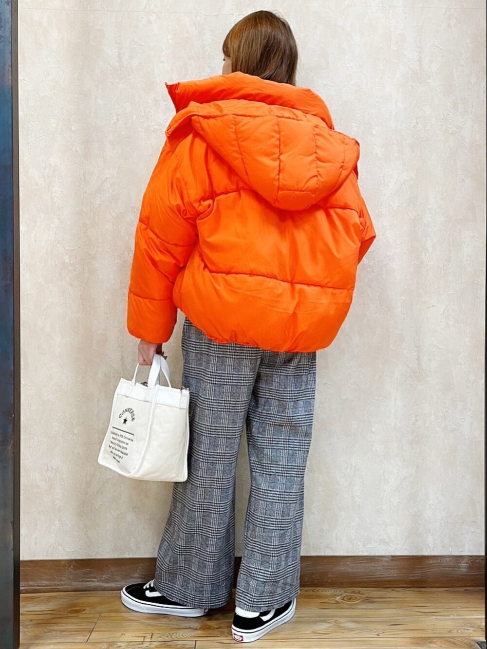 オレンジ系のブルゾン、ブラック系のスウェット、ホワイト系のショルダーバッグを着用したレディースの冬コーディネートの3枚目の写真