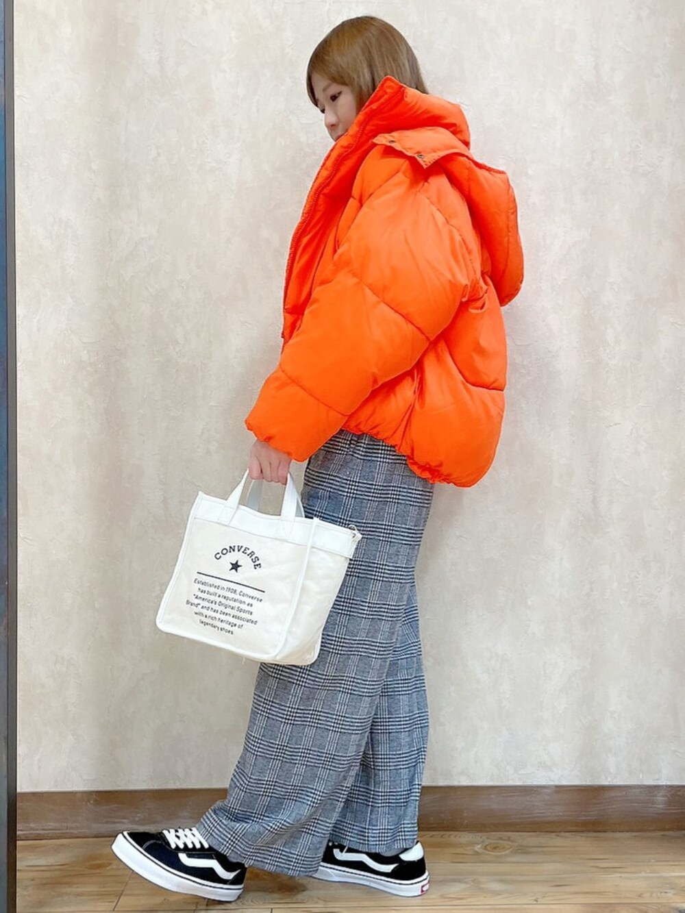 オレンジ系のブルゾン、ブラック系のスウェット、ホワイト系のショルダーバッグを着用したレディースの冬コーディネートの2枚目の写真